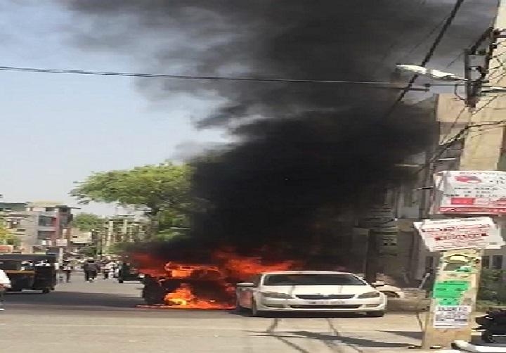 रोड पर खड़ी कार में लगी आग, लोगों ने दो कारों को जलने से बचाया